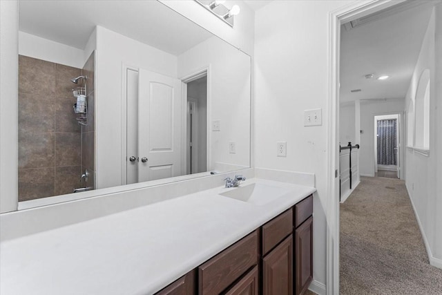 full bathroom featuring vanity, baseboards, and a tile shower