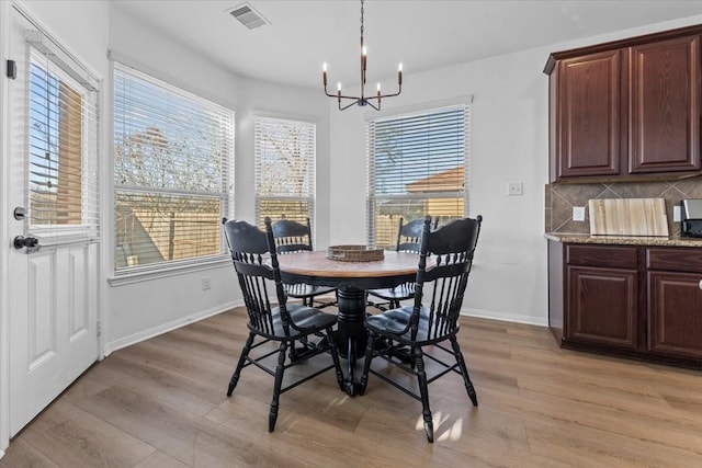 dining area with visible vents, light wood-type flooring, and baseboards