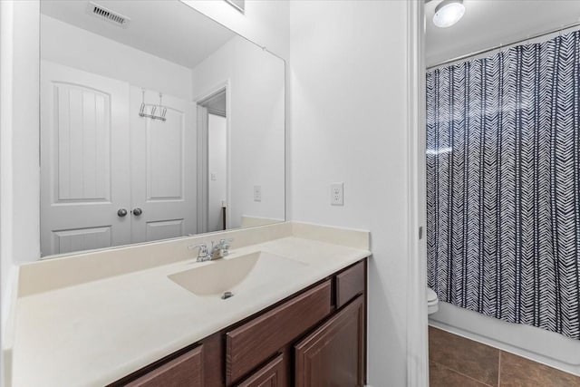 bathroom with tile patterned floors, visible vents, toilet, and vanity