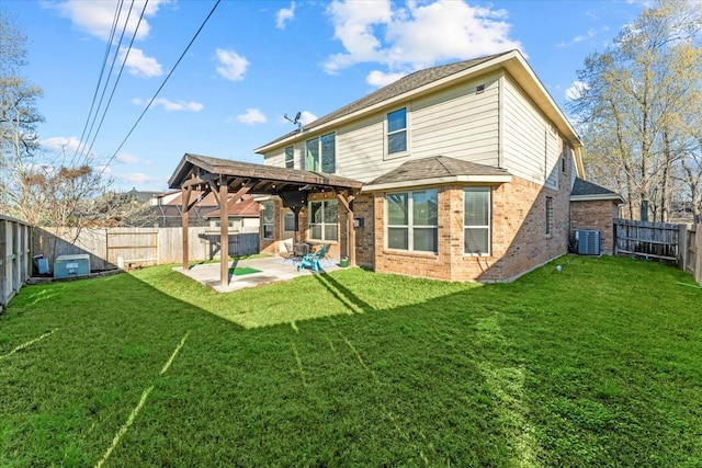 rear view of house featuring a fenced backyard, a yard, brick siding, central AC unit, and a patio area