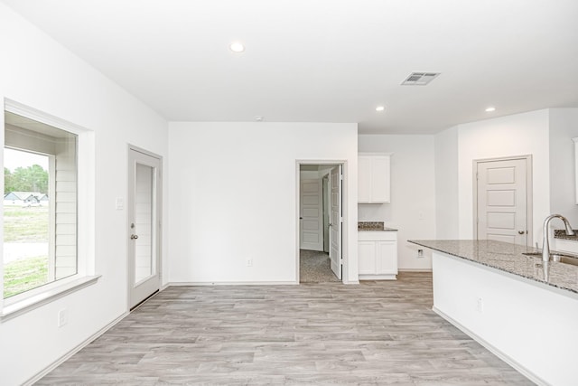 interior space with recessed lighting, visible vents, light wood finished floors, and a sink