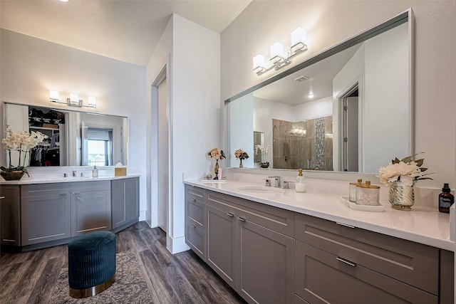 full bathroom with visible vents, vanity, wood finished floors, and a shower stall