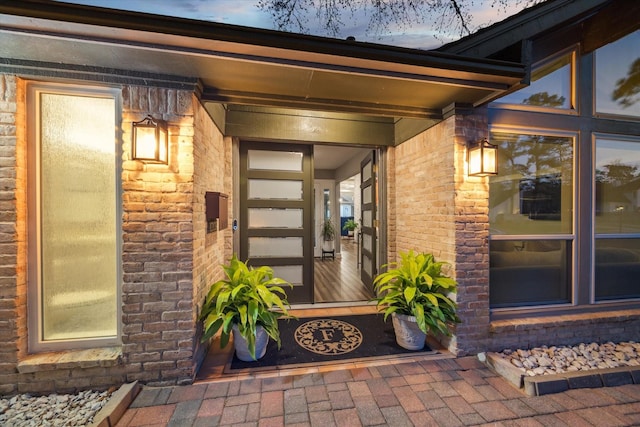 doorway to property featuring brick siding