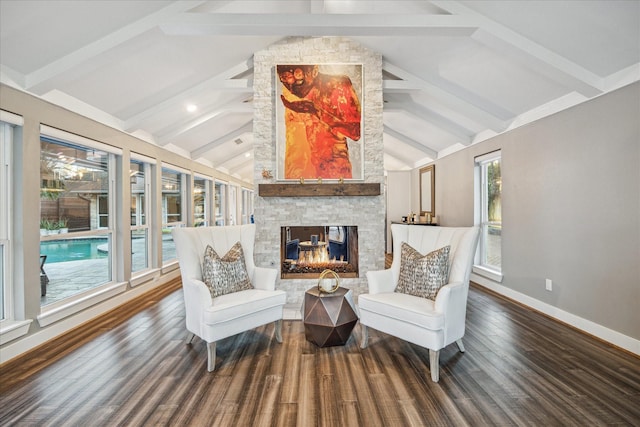 sitting room featuring lofted ceiling with beams, wood finished floors, a fireplace, and baseboards