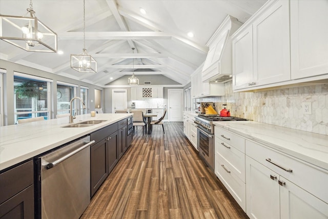 kitchen with a sink, tasteful backsplash, stainless steel appliances, white cabinets, and a chandelier