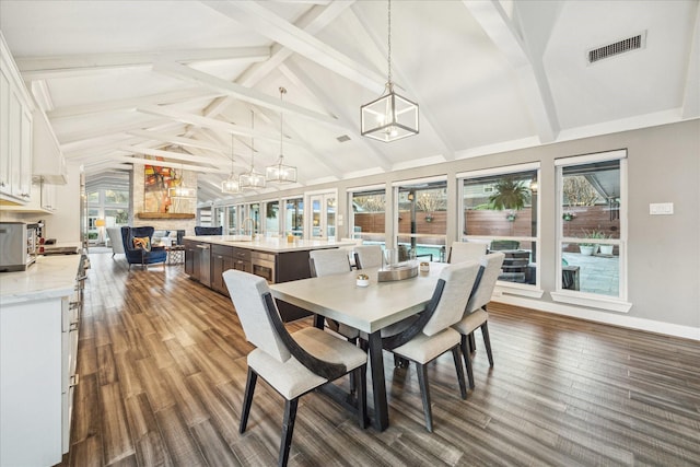 dining room featuring dark wood-type flooring, beamed ceiling, a notable chandelier, and visible vents