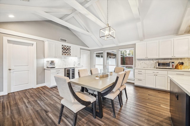 dining space featuring wine cooler, lofted ceiling with beams, bar area, and dark wood-style flooring