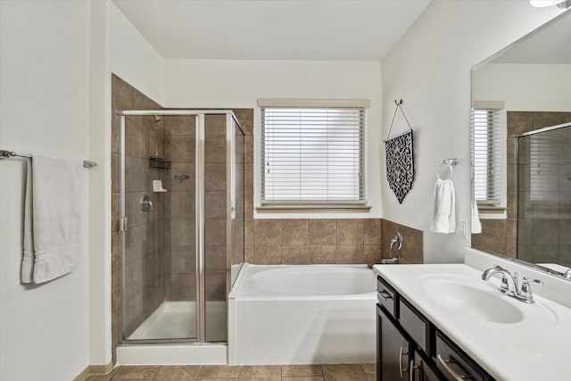 bathroom featuring tile patterned floors, vanity, a bath, and a shower stall