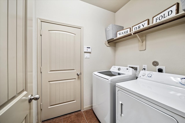 laundry room with dark tile patterned flooring, laundry area, and washing machine and clothes dryer