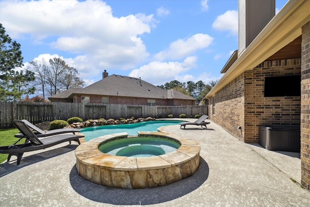 view of swimming pool with a pool with connected hot tub, a fenced backyard, and a patio area