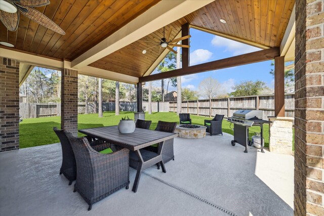 view of patio / terrace featuring a fire pit, a fenced backyard, outdoor dining space, a grill, and a ceiling fan