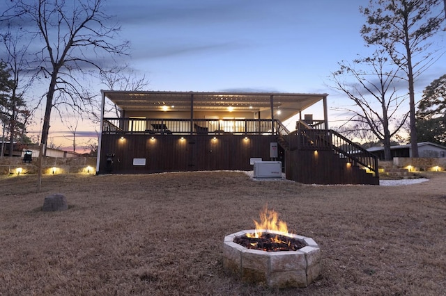 back of property with stairway, a fire pit, and a wooden deck