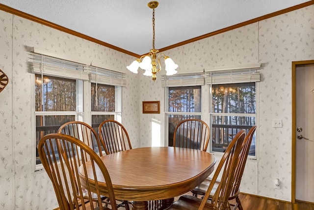 dining space with wallpapered walls, wood finished floors, a chandelier, and ornamental molding