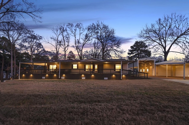 rear view of house with a lawn and a carport