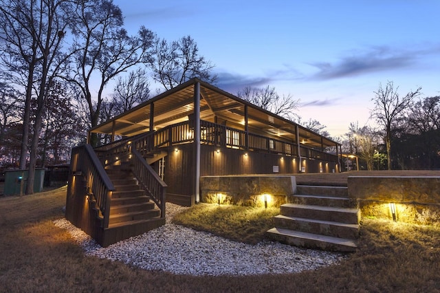 back of property at dusk featuring stairway