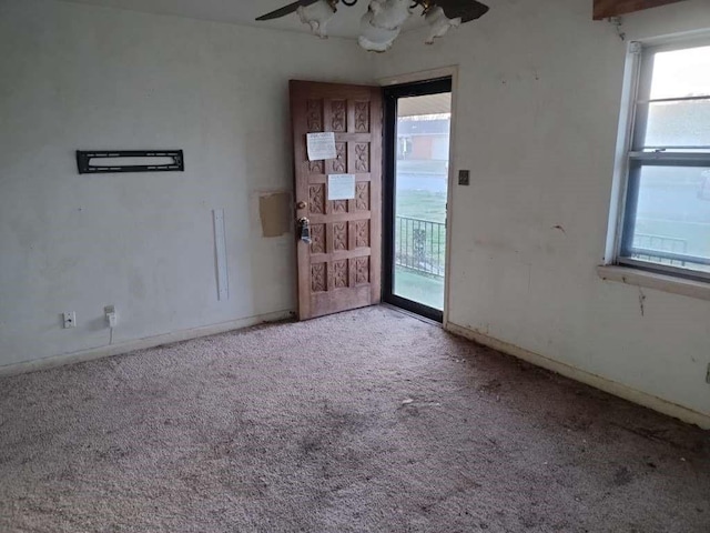 unfurnished room with baseboards, carpet, and a ceiling fan