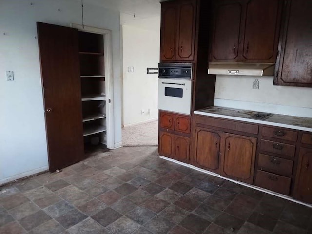 kitchen featuring black electric stovetop, stone finish flooring, range hood, white oven, and baseboards