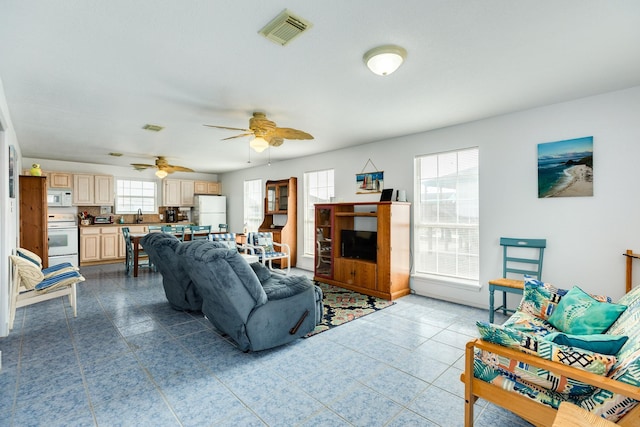 living area featuring visible vents, ceiling fan, and dark tile patterned flooring