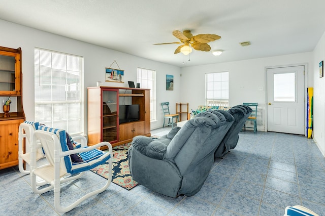 living area with visible vents, a healthy amount of sunlight, and ceiling fan