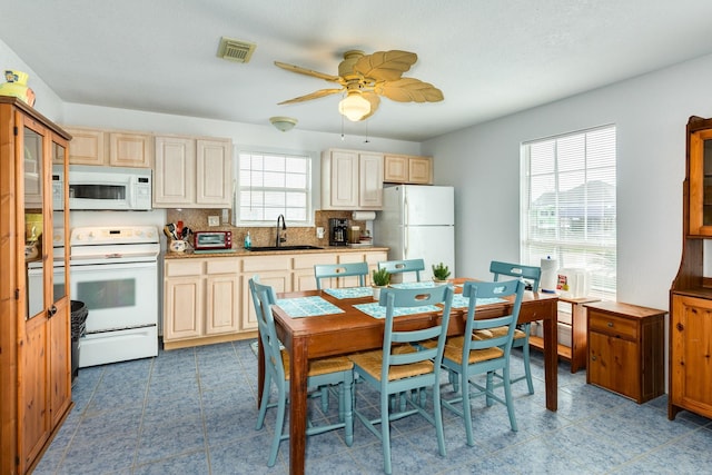 kitchen with visible vents, backsplash, ceiling fan, white appliances, and a sink