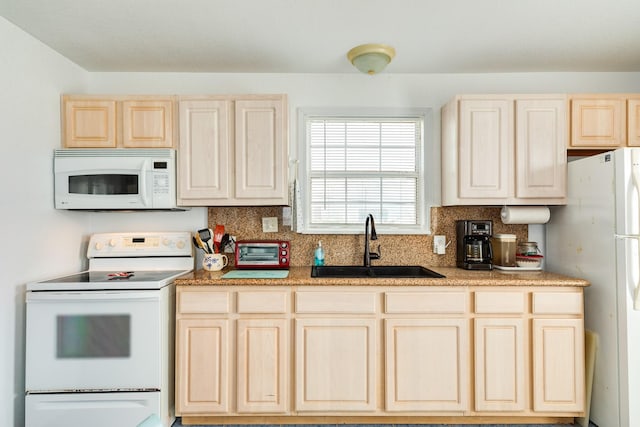 kitchen featuring tasteful backsplash, white appliances, light brown cabinetry, and a sink