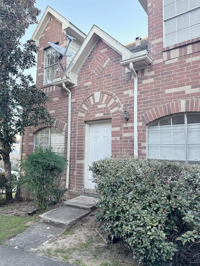 doorway to property with brick siding