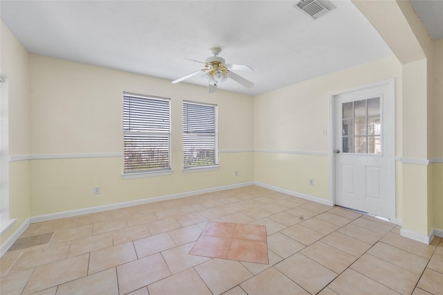 spare room with light tile patterned floors, visible vents, baseboards, and ceiling fan