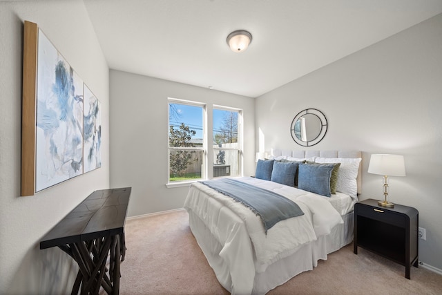 bedroom featuring light colored carpet and baseboards