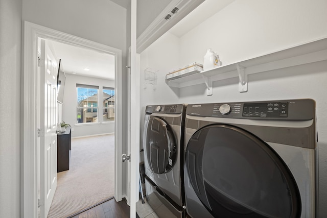 clothes washing area featuring baseboards, carpet, laundry area, and washing machine and clothes dryer