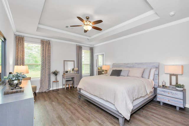 bedroom featuring a tray ceiling, crown molding, and wood finished floors