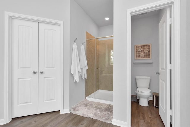 full bath featuring wood finished floors, baseboards, visible vents, a shower stall, and toilet