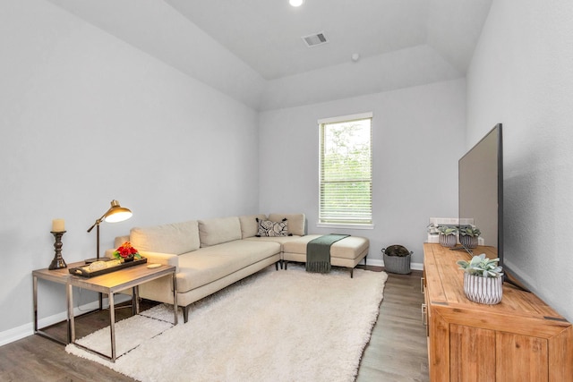 living room featuring visible vents, baseboards, and wood finished floors