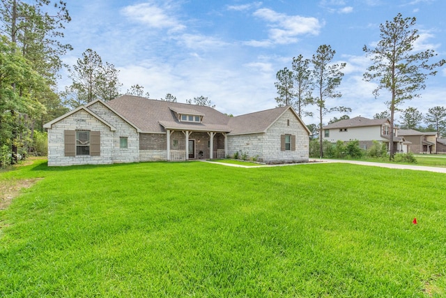 french country style house with driveway, roof with shingles, and a front yard