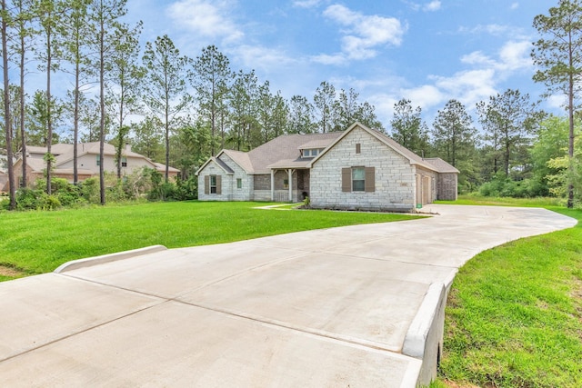 view of front facade featuring stone siding, driveway, and a front yard