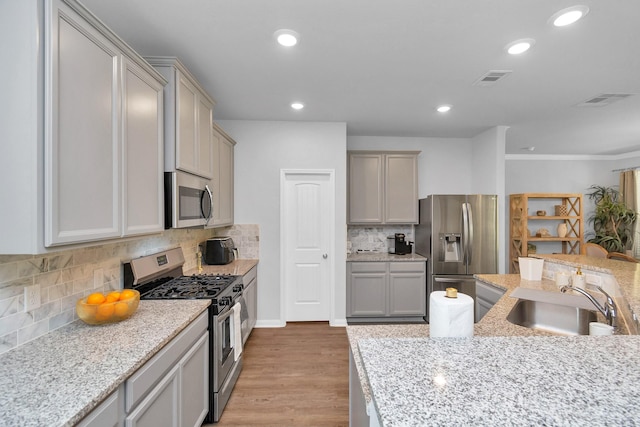 kitchen featuring a sink, recessed lighting, light wood finished floors, and stainless steel appliances