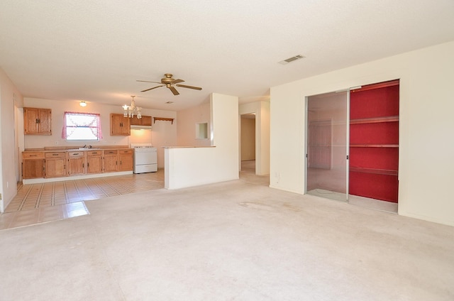 unfurnished living room with visible vents, light carpet, ceiling fan with notable chandelier, a textured ceiling, and a sink