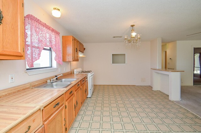 kitchen with visible vents, white gas stove, a sink, an inviting chandelier, and light countertops