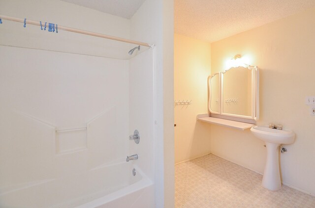 bathroom featuring tile patterned floors, a textured ceiling, and  shower combination