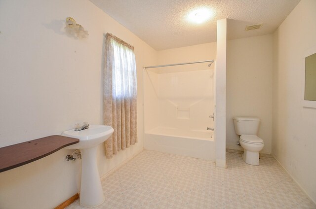 full bath with visible vents, toilet, shower / tub combination, and a textured ceiling