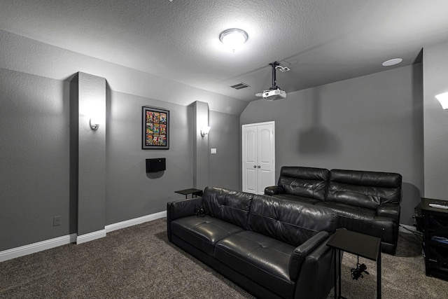 home theater with visible vents, baseboards, carpet, lofted ceiling, and a textured ceiling