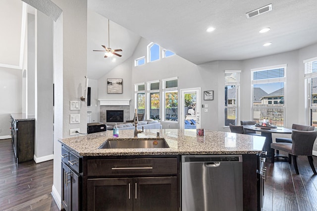 kitchen featuring a glass covered fireplace, dark wood finished floors, a sink, dishwasher, and open floor plan