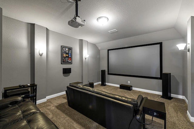 cinema room with visible vents, carpet floors, baseboards, and vaulted ceiling