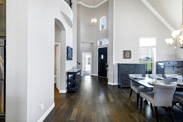 dining room with a notable chandelier, ornamental molding, baseboards, and dark wood-style flooring