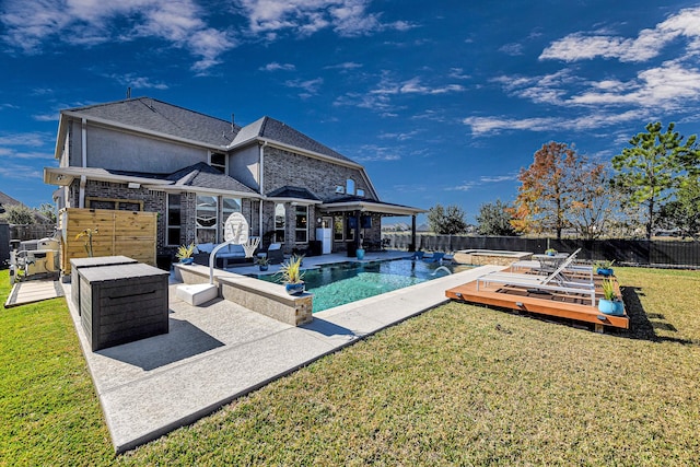 exterior space featuring a fenced backyard, a deck, a pool with connected hot tub, and a yard