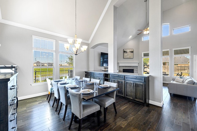 dining area featuring baseboards, high vaulted ceiling, a fireplace, and dark wood-style flooring