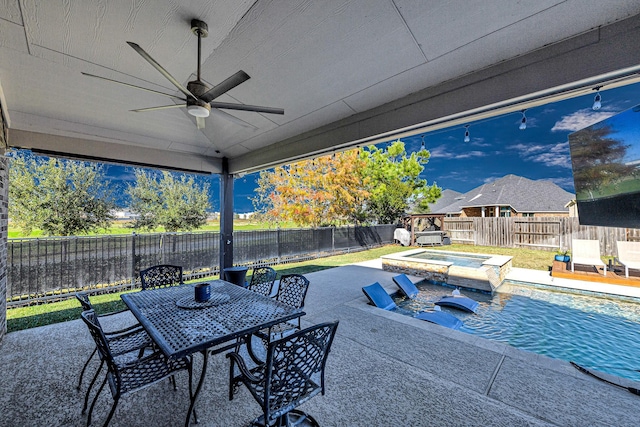 view of patio featuring a fenced backyard, an in ground hot tub, outdoor dining area, and a ceiling fan