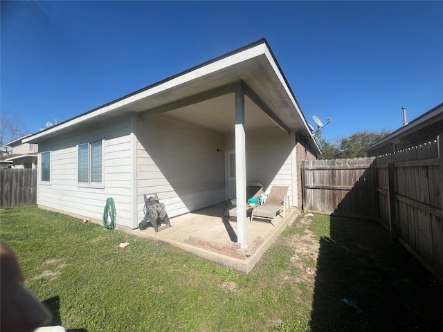 back of house with a patio, a yard, and a fenced backyard