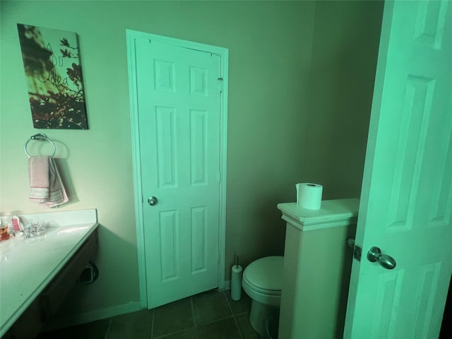 bathroom featuring tile patterned flooring, toilet, and baseboards