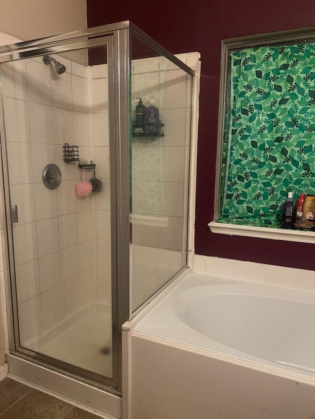 full bath with tile patterned flooring, a bath, and a stall shower