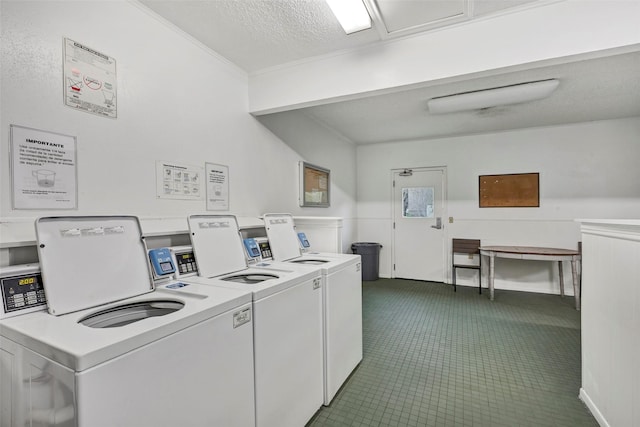 community laundry room featuring a textured ceiling, crown molding, and separate washer and dryer